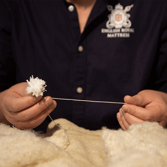 Craftsman demonstrating meticulous craftsmanship in the making of English Royal Mattress for ultimate luxury sleep experience.