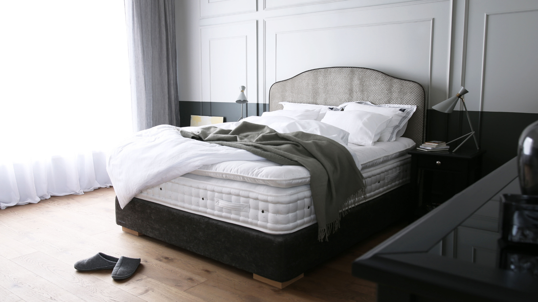 Waarom een Engelse matras de beste keuze is ? Comfortabele slaapkamer met een hoogwaardige Engelse matras, beddengoed en slippers.